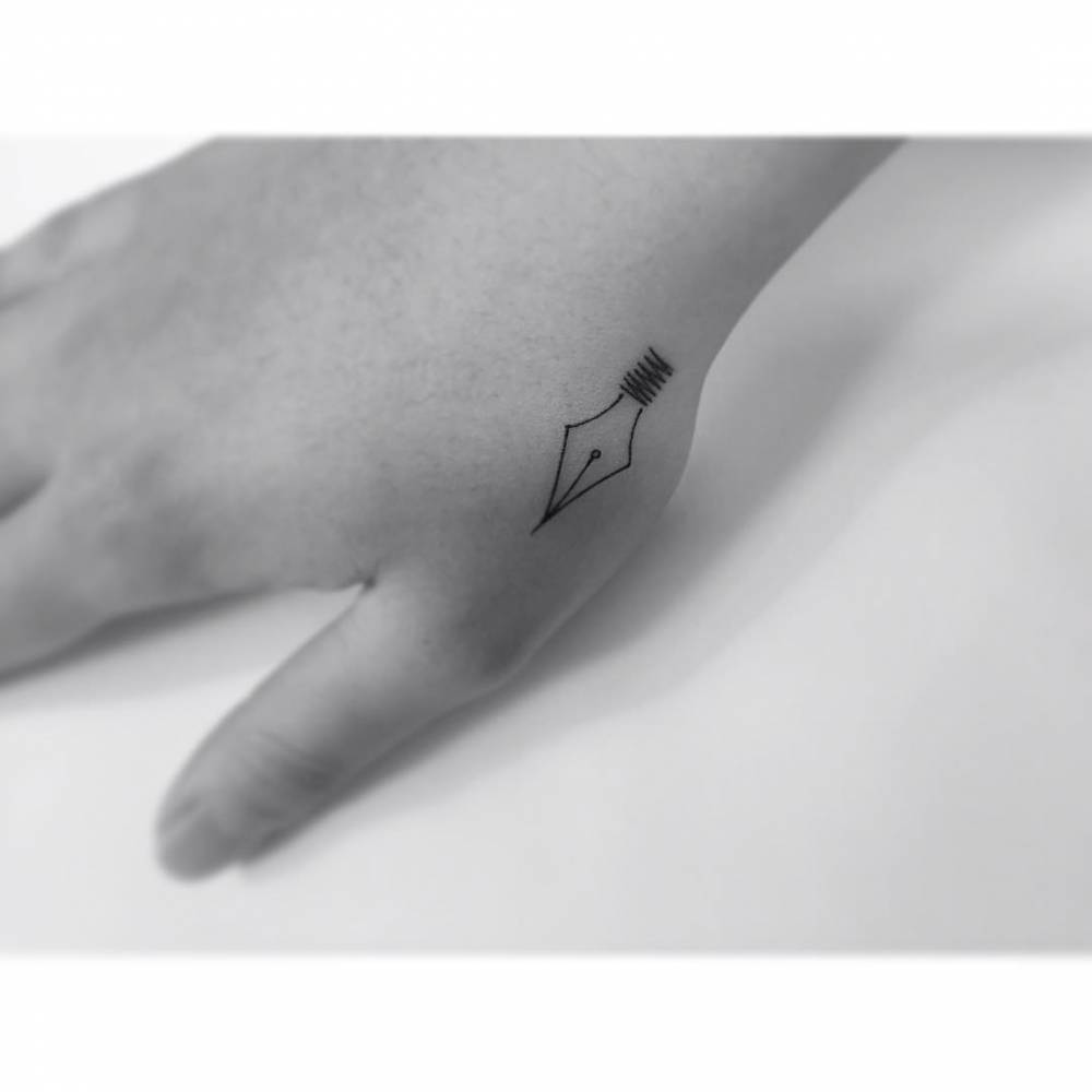 Minimalistic style pen tip tattoo located on the hand.