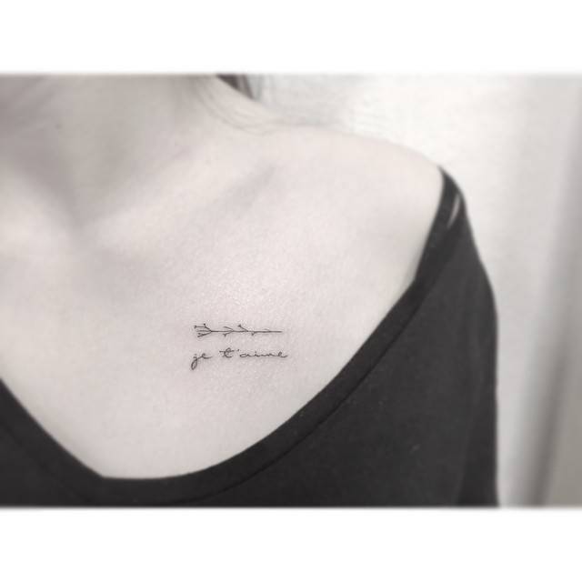 "Je t'aime" and minimalistic flower tattooed on the chest.