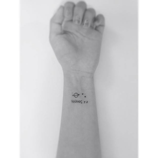 Minimalistic style Saturn and stars tattoo located on the wrist.
