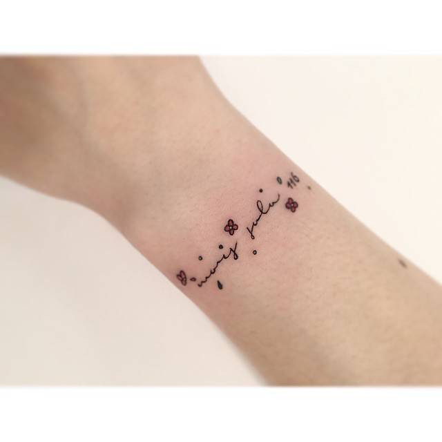 "Mors sola" and flowers tattoo located on the wrist, minimalistic style.