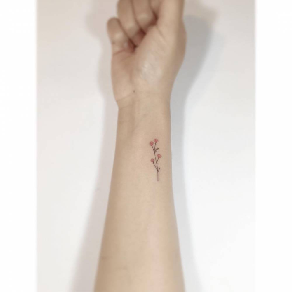 Flowers tattoo in minimalistic style located on the wrist.