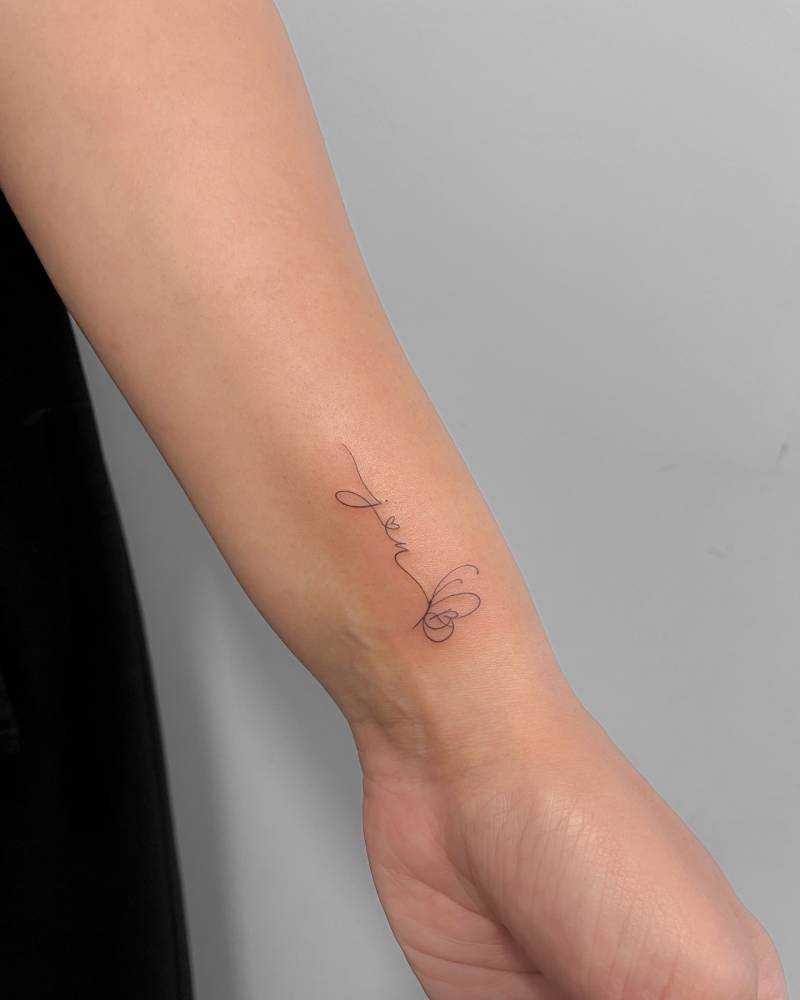 Initials and butterfly tattoo located on the wrist, fine line style.