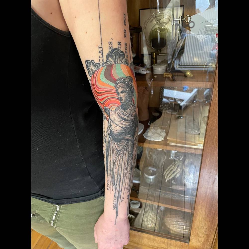 Graphic style Athena tattoo located on the arm.