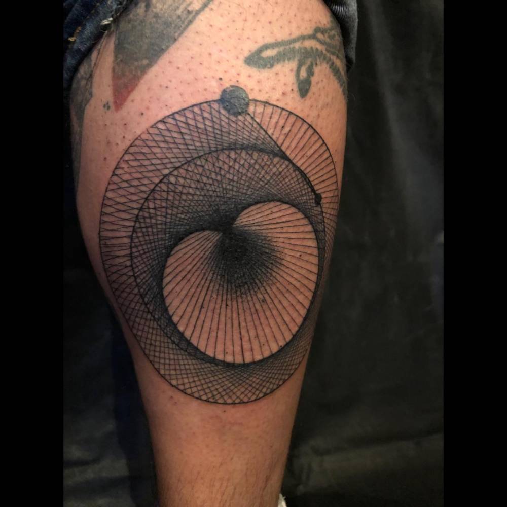 Geometric style tattoo located on the calf.