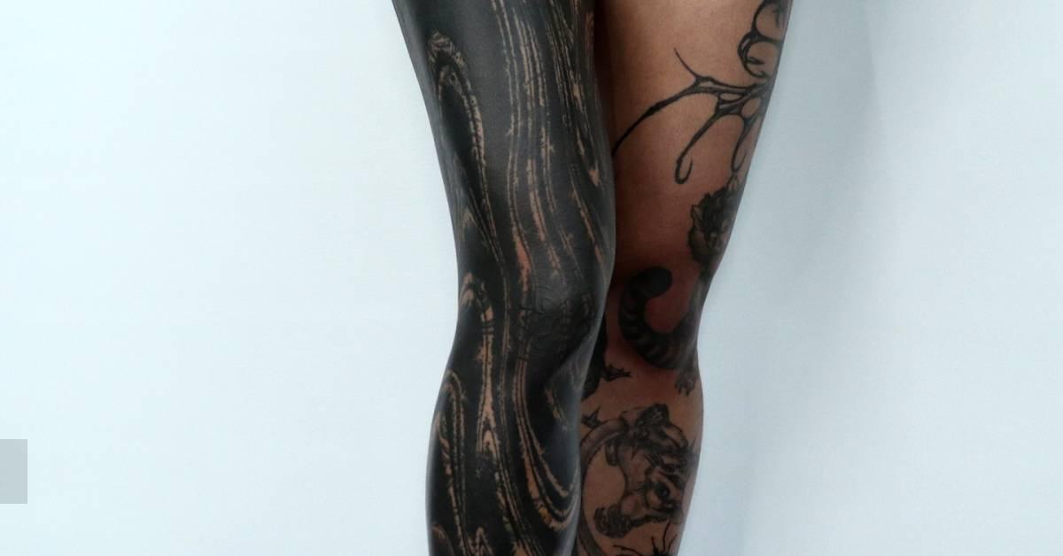 Abstract cover up leg sleeve tattoo in blackwork style.