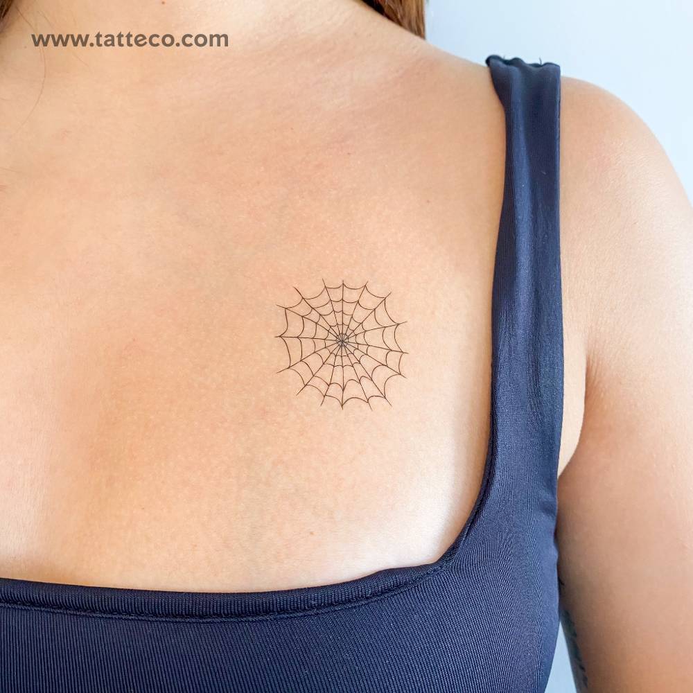 Fine line style spiderweb temporary tattoo located on the chest.