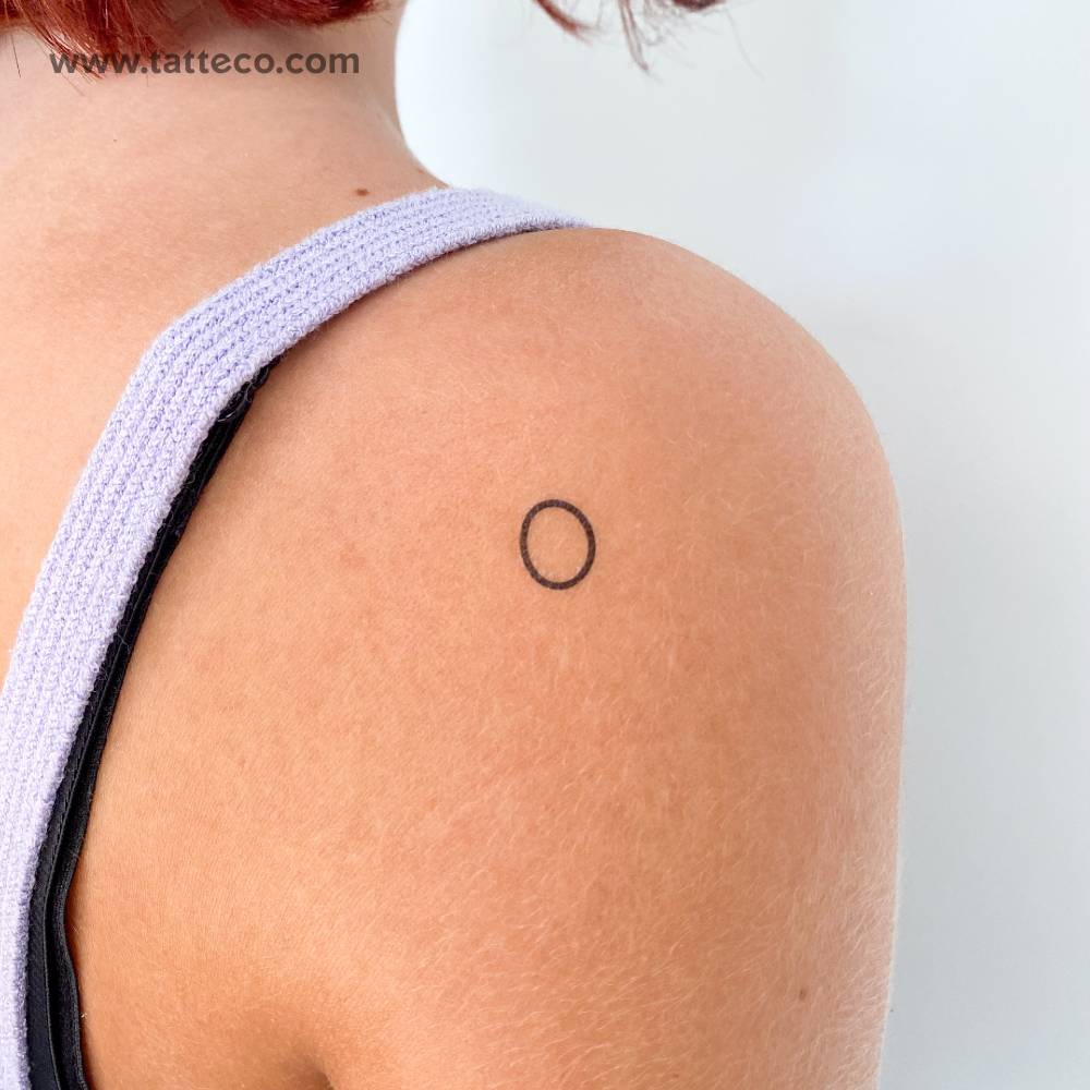 Little minimalistic circle temporary tattoo located on the shoulder.