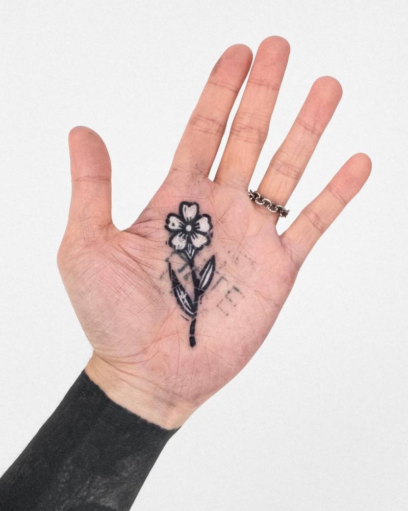 Pop art style flower tattoo located on the palm.