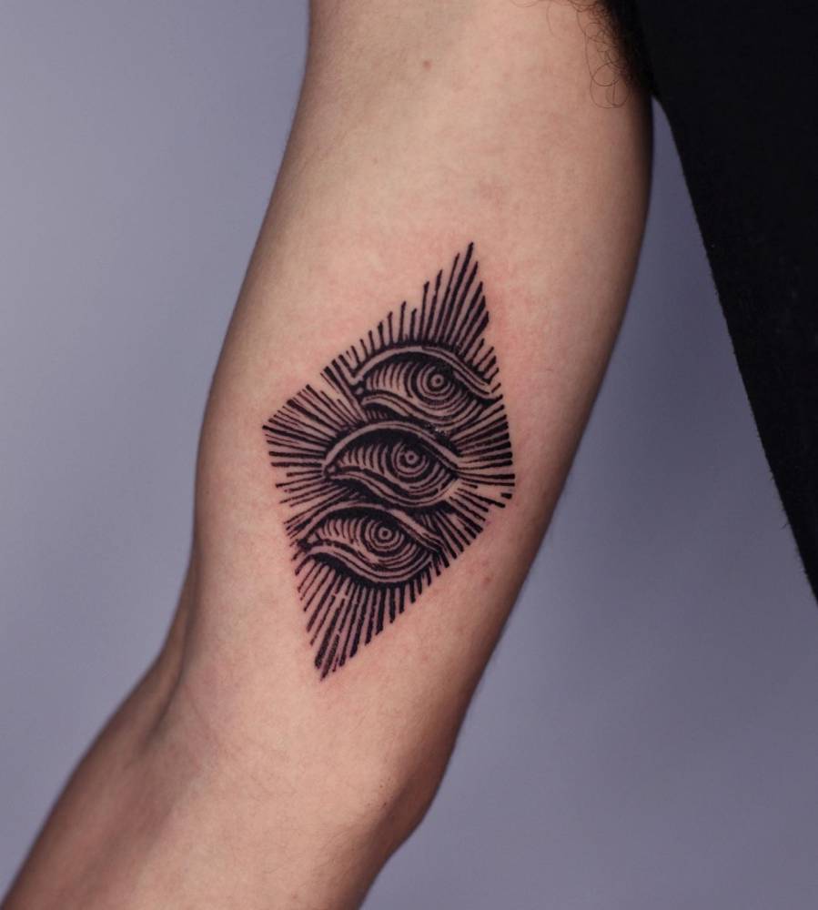 Eyes tattoo in engraving style located on the inner arm.