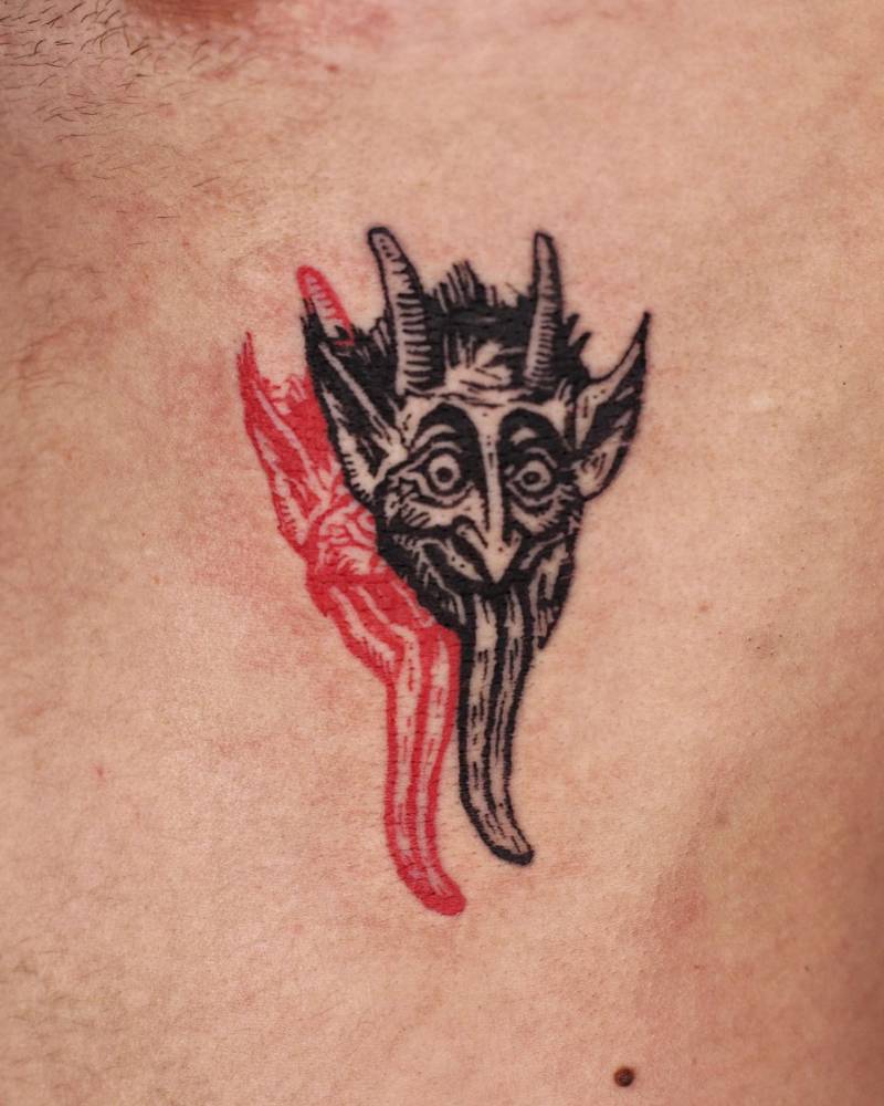 Engraving style devil portrait tattoo located on the rib.