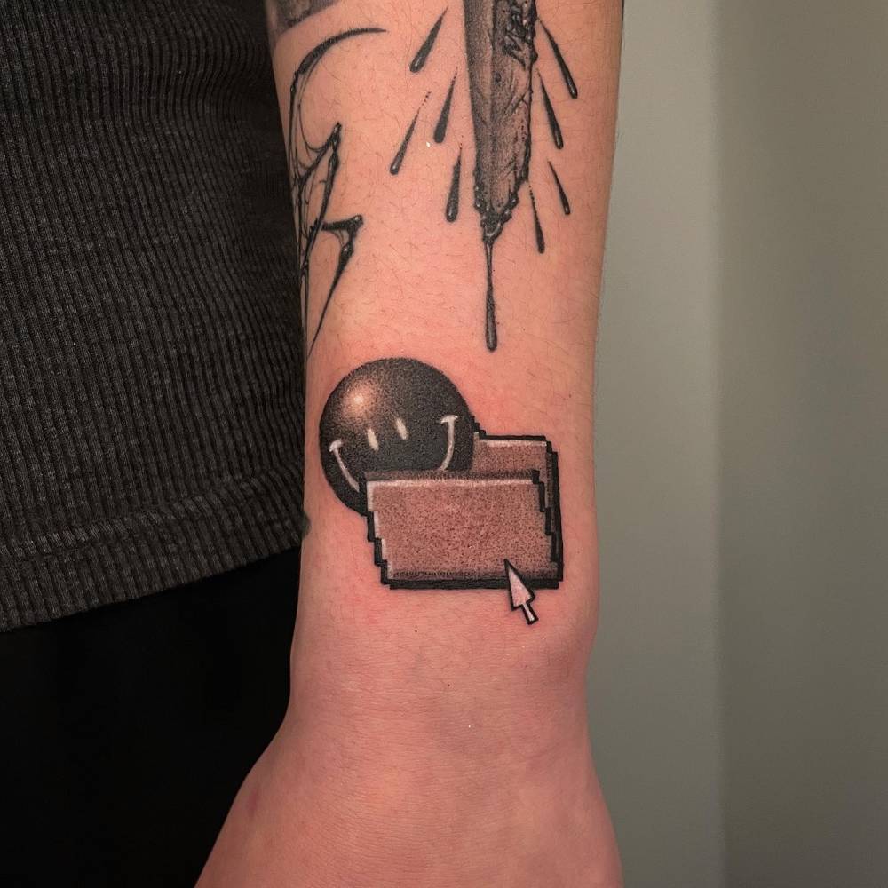 Smiley computer file tattoo located on the wrist.