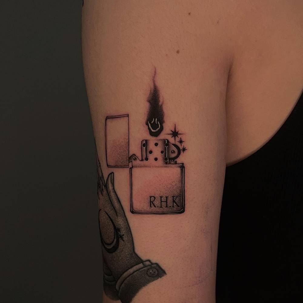 Illustrative style lighter tattoo placed on the tricep.