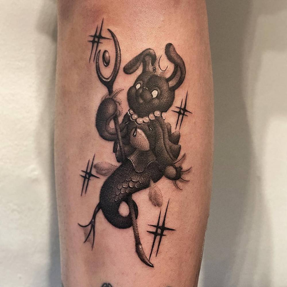 Cartoon style mermaid teddy bunny tattoo located on the calf.