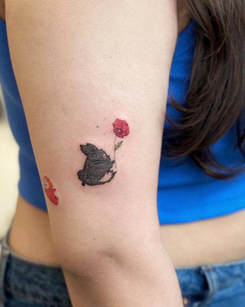 Chuu Totoro tattoo in cartoon style located on the upper arm.