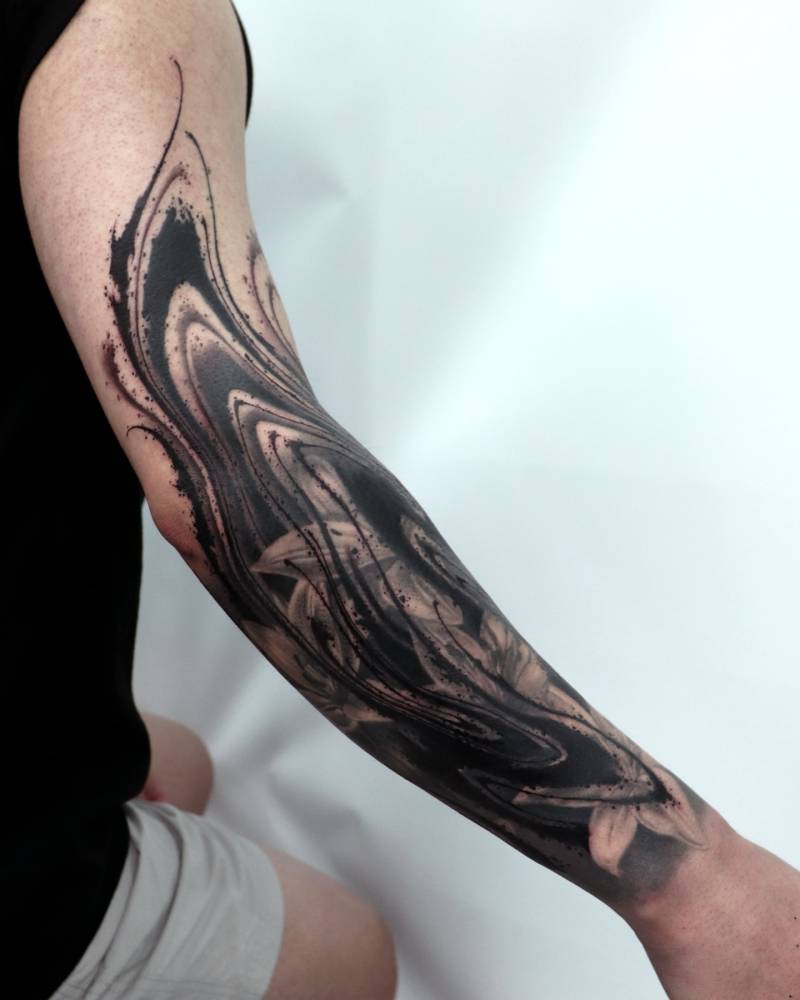 Abstract style cover-up tattoo located on the arm.