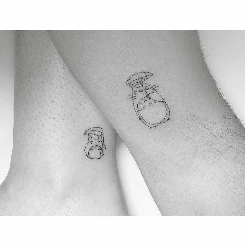 Matching Totoro tattoo in fine line style for couple.