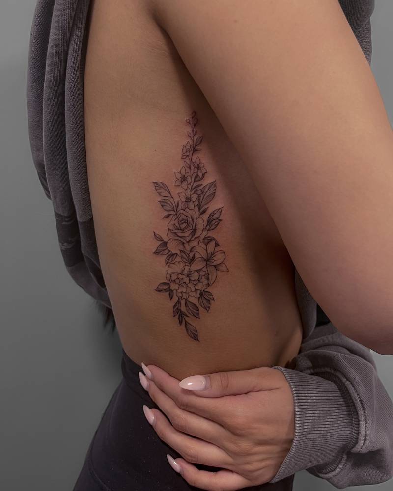 Flower collection tattoo in illustrative style placed on the rib.