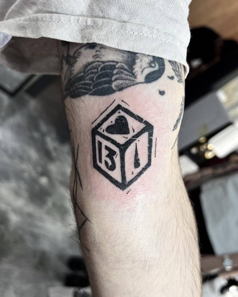 Lucky dice tattoo in blackwork style located on the inner arm.