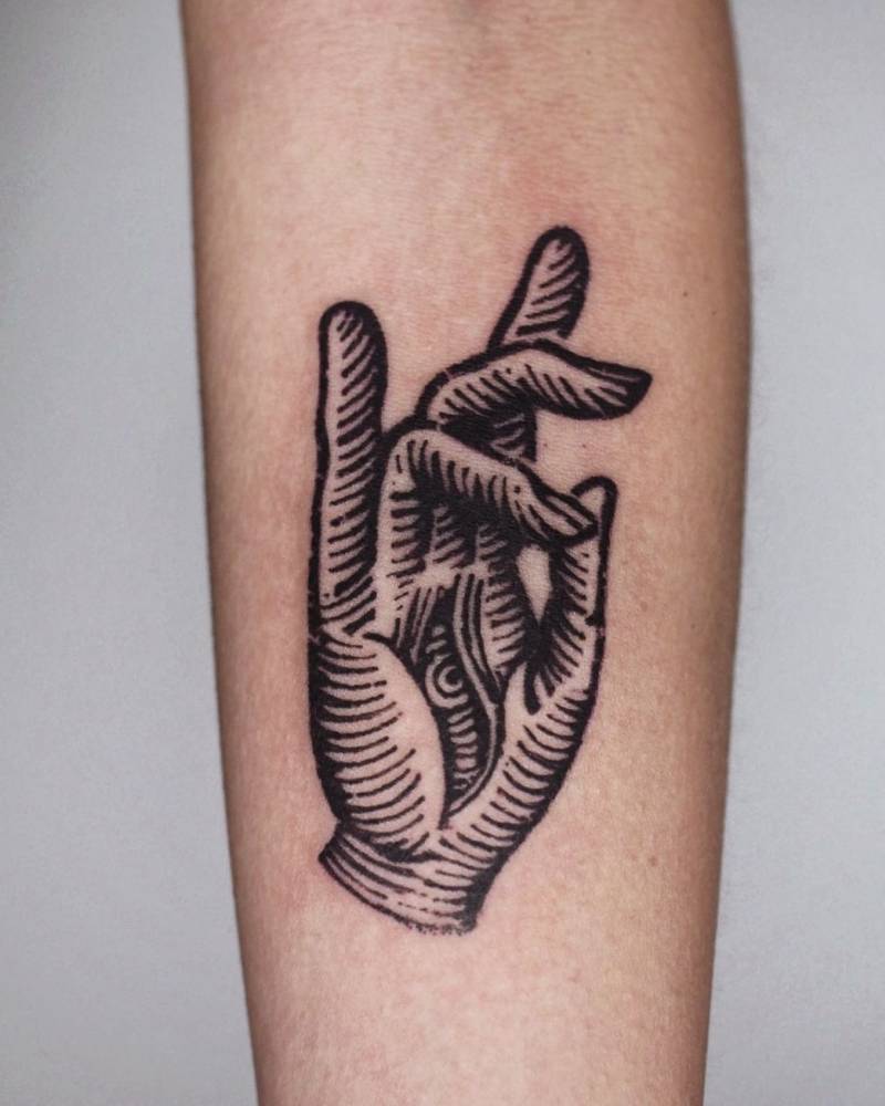 Engraving style hand tattoo located on the inner forearm.