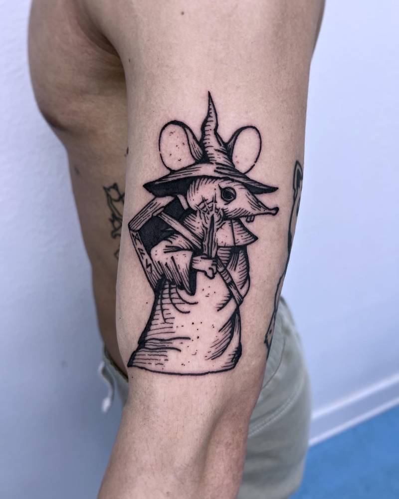 Wizard rat tattoo in engraving style tattoo located on the upper arm.