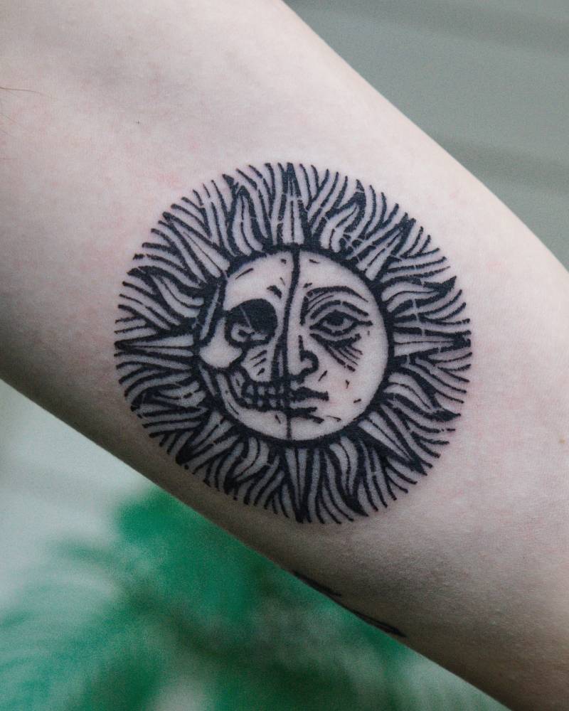 Inti sun tattoo in engraving style located on the inner arm.
