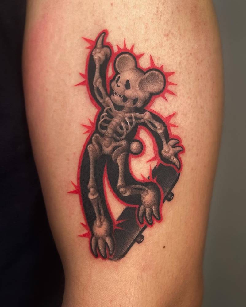 Skater teddy bear tattoo located on the upper arm, dotwork style.