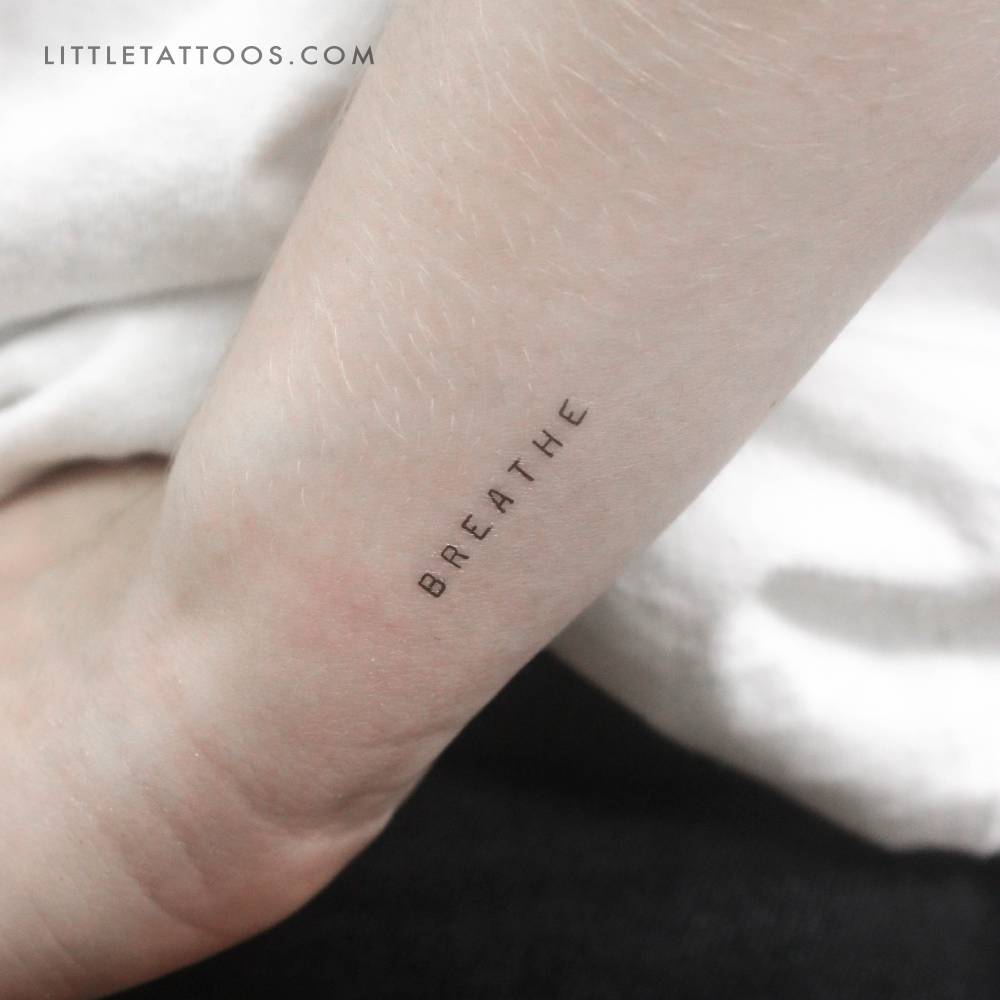 Uppercase word "breathe" temporary tattoo located on the wrist.