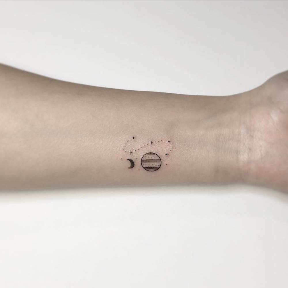 Minimalistic style universe tattoo located on the wrist.
