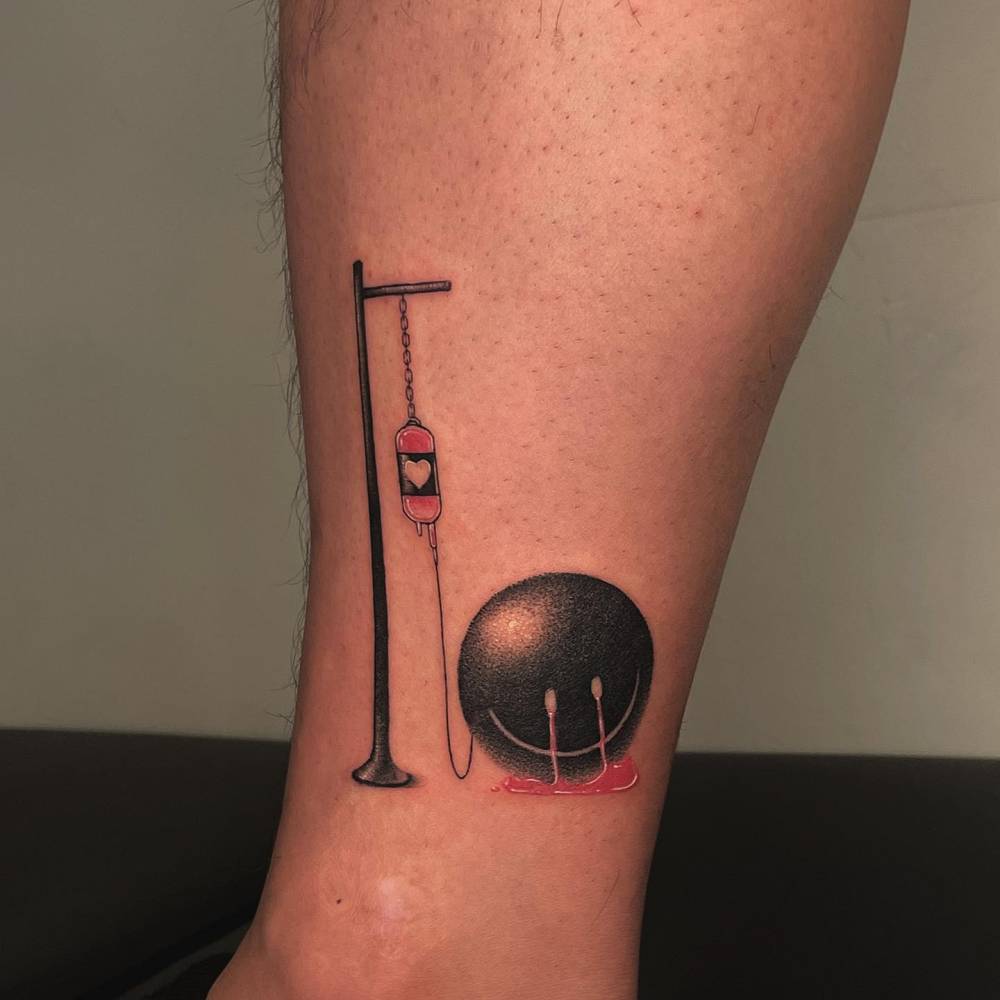 Smiley having IV therapy tattooed on the shin, dotwork style.