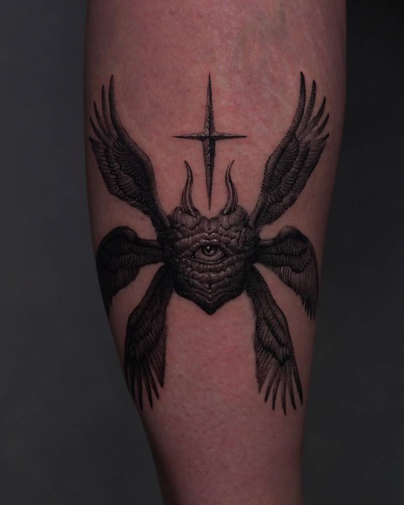 Black and grey style seraphim heart tattoo placed on the calf.