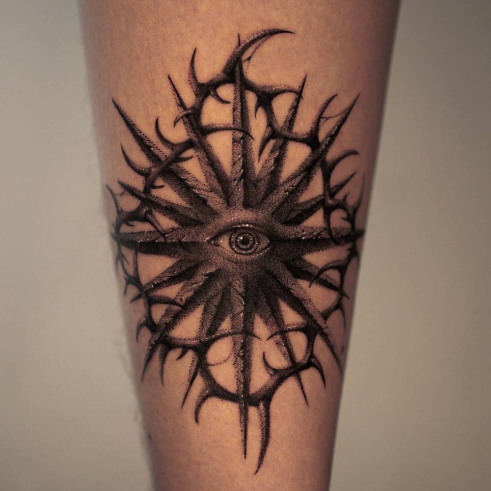 Star, eye and thorns tattoo in dotwork style placed on the achilles.