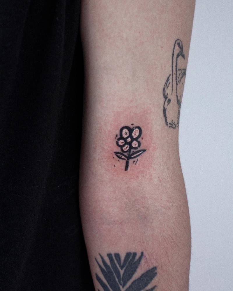 Flower tattoo in pop art style located on the bicep.