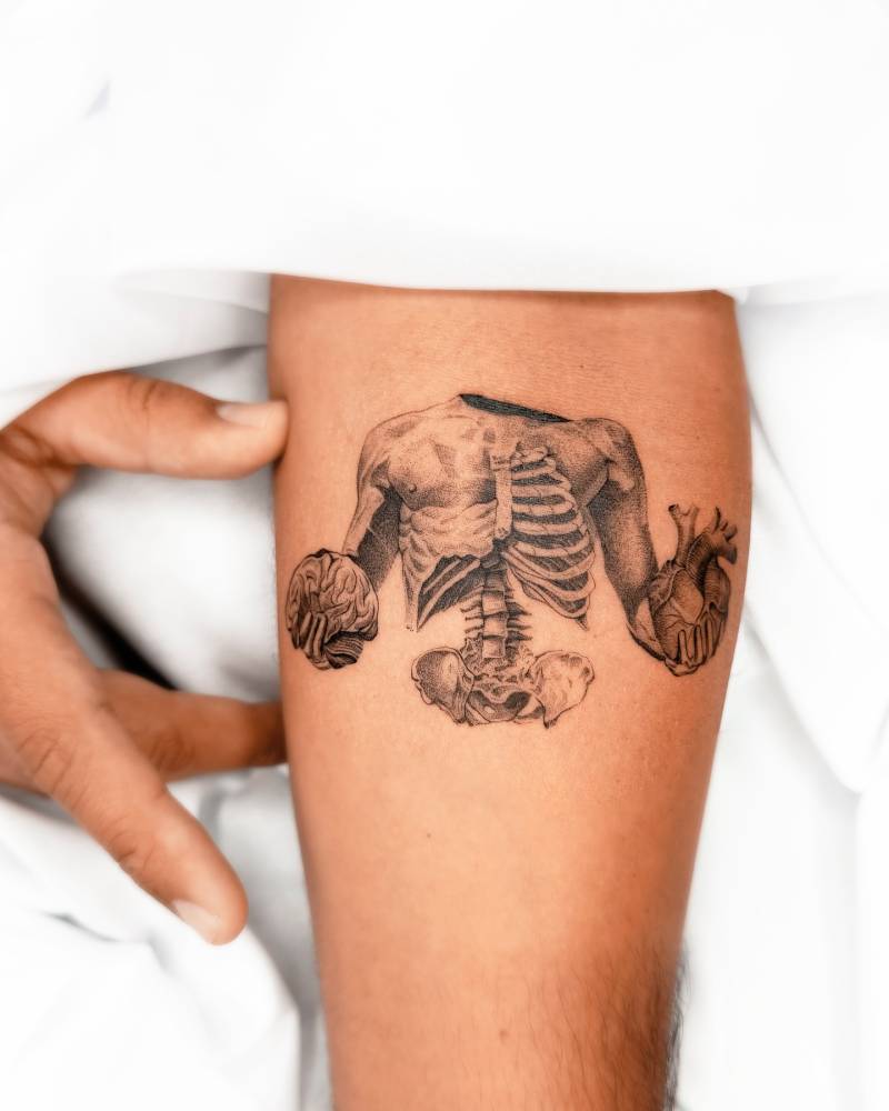 Heart vs. brain tattoo in micro-realistic style placed on the inner forearm.