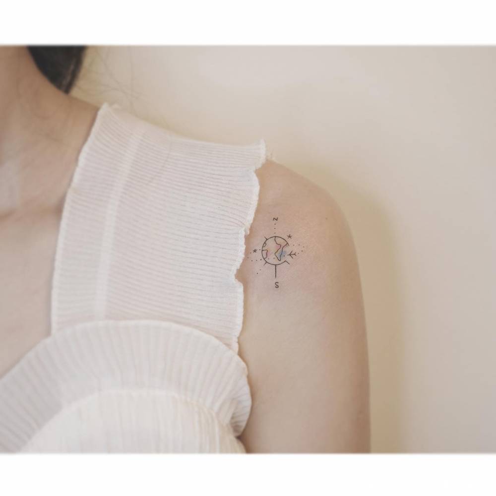 Around the world compass rose tattoo located on the shoulder, minimalistic style.