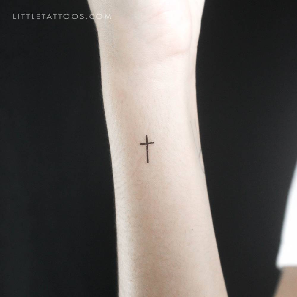 Small minimalist cross temporary tattoo done on the wrist.