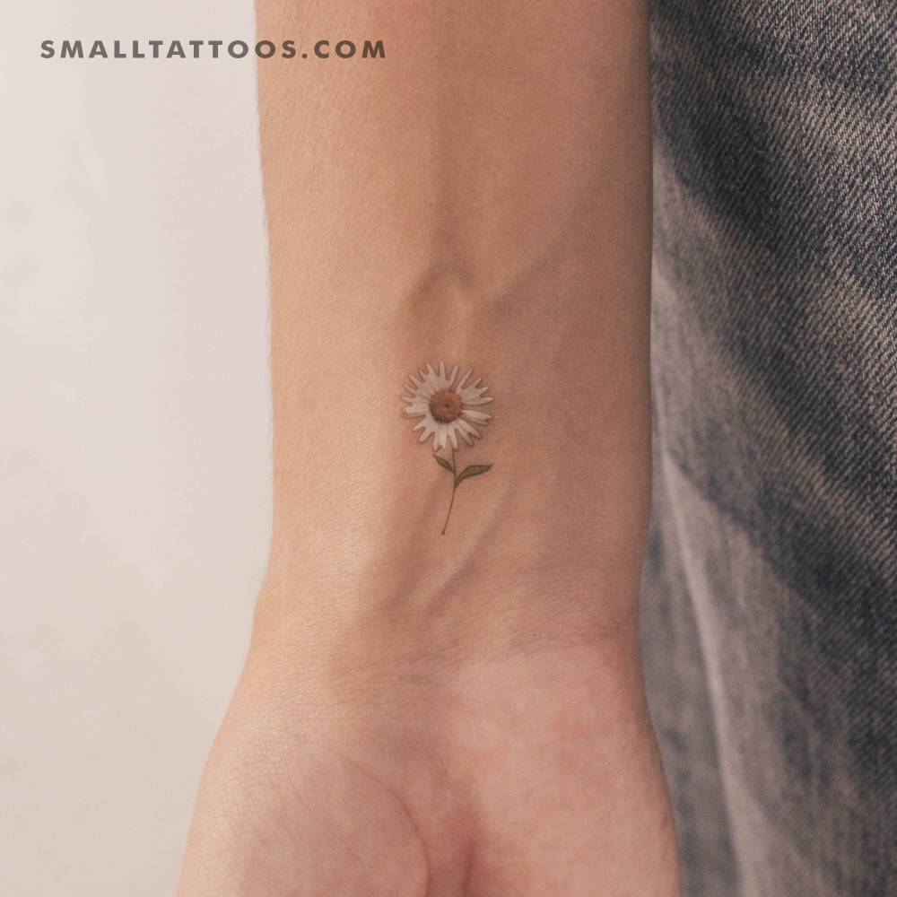 Small watercolor style daisy temporary tattoo located on the wrist.