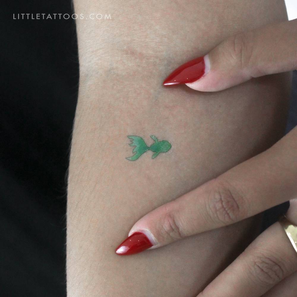 Green fish temporary tattoo located on the inner forearm.