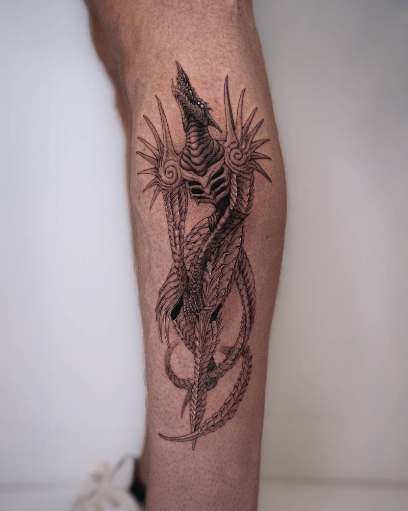Dragon tattoo in illustrative style located on the shin.