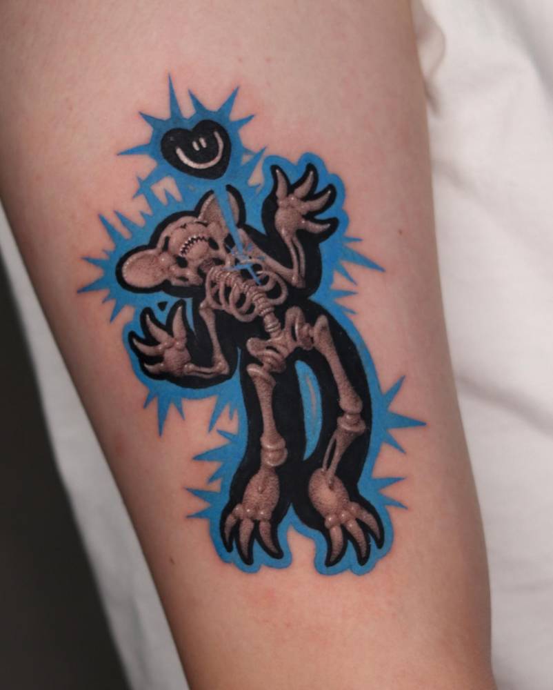 X-ray bear tattoo located on the upper arm, done in pop art style.