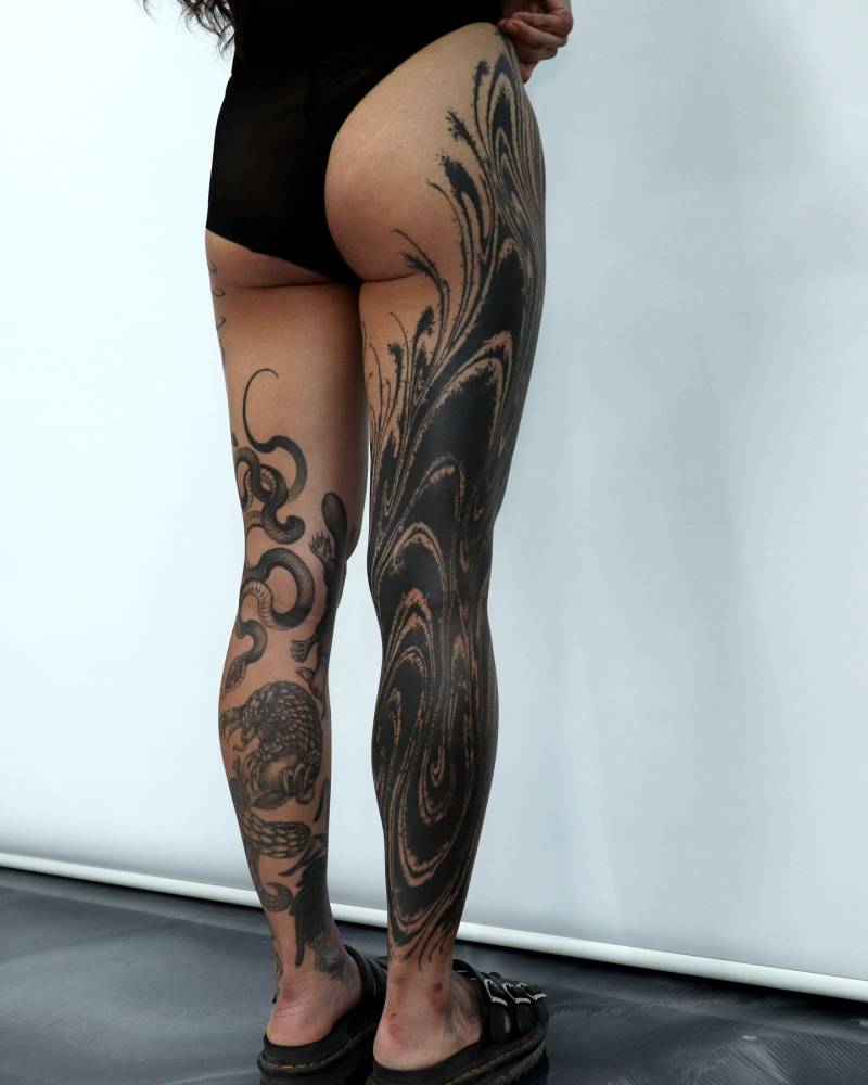 Abstract leg sleeve tattoo in blackwork style.