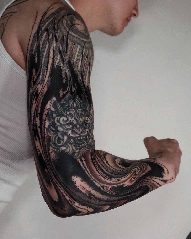 Abstract style flow cover up tattoo located on the arm.