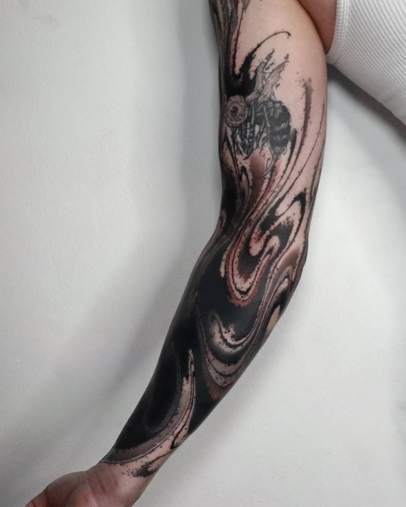 Abstract style flow cover up tattoo located on the arm.