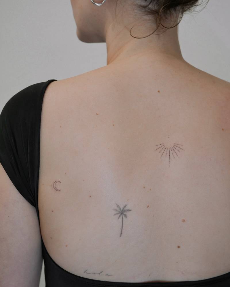 Fine line style sun and moon tattoo located on the back.