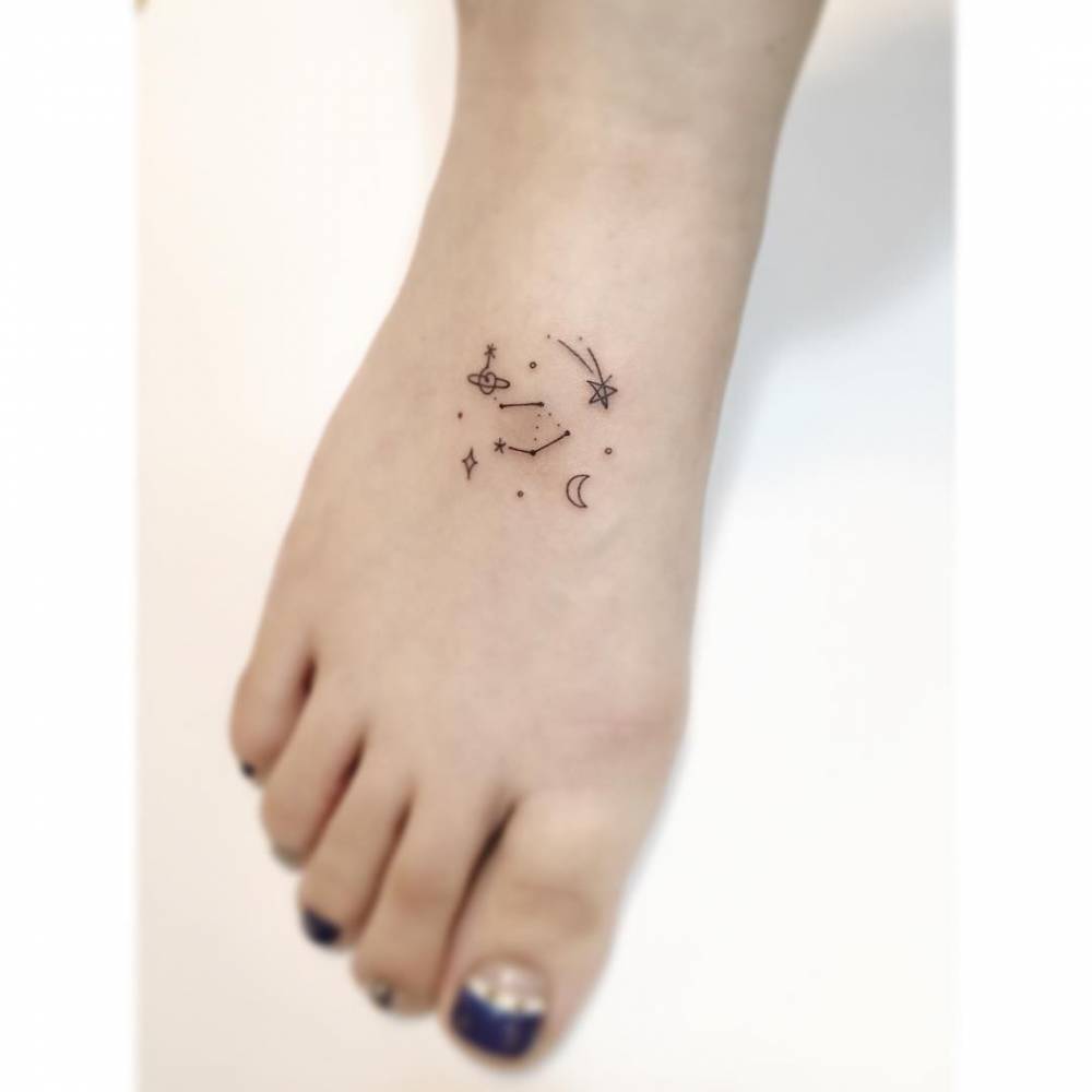 Libra constellation and universe tattoo in minimalistic style located on the foot.