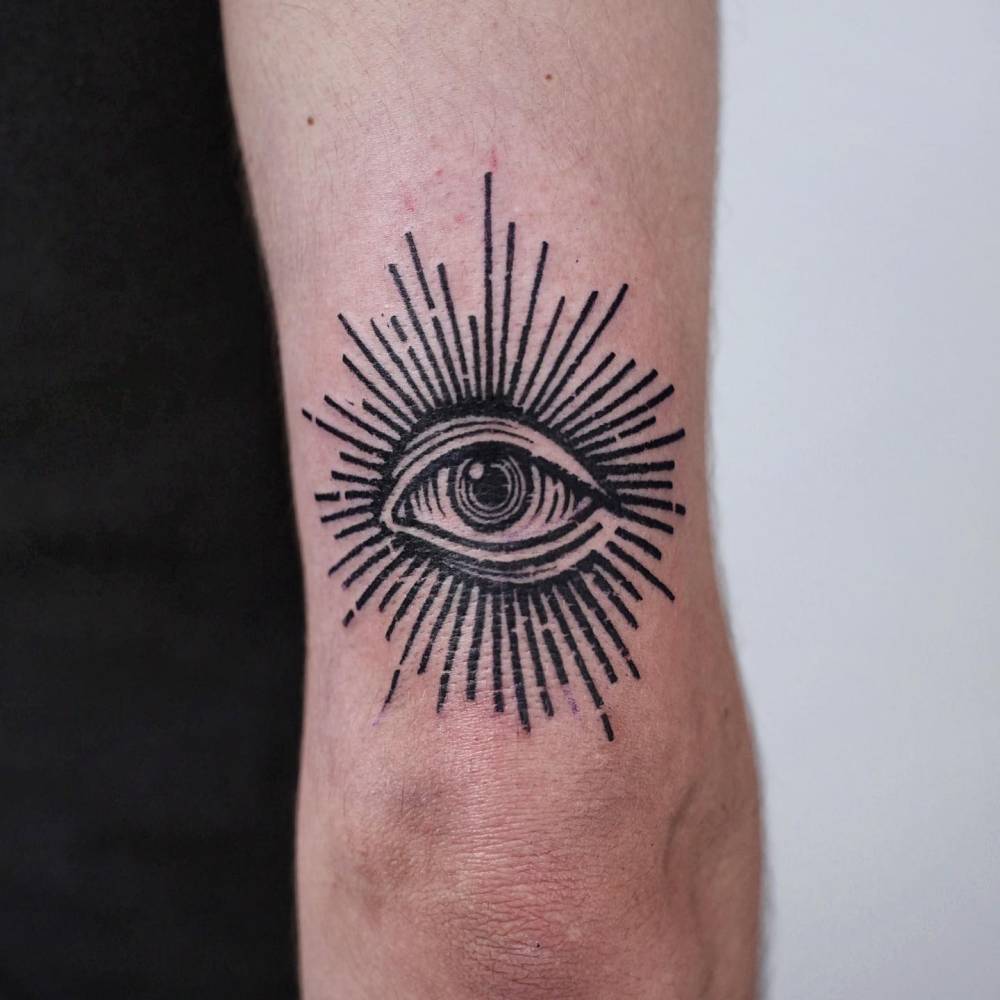 Eye tattoo in engraving style placed on the tricep.