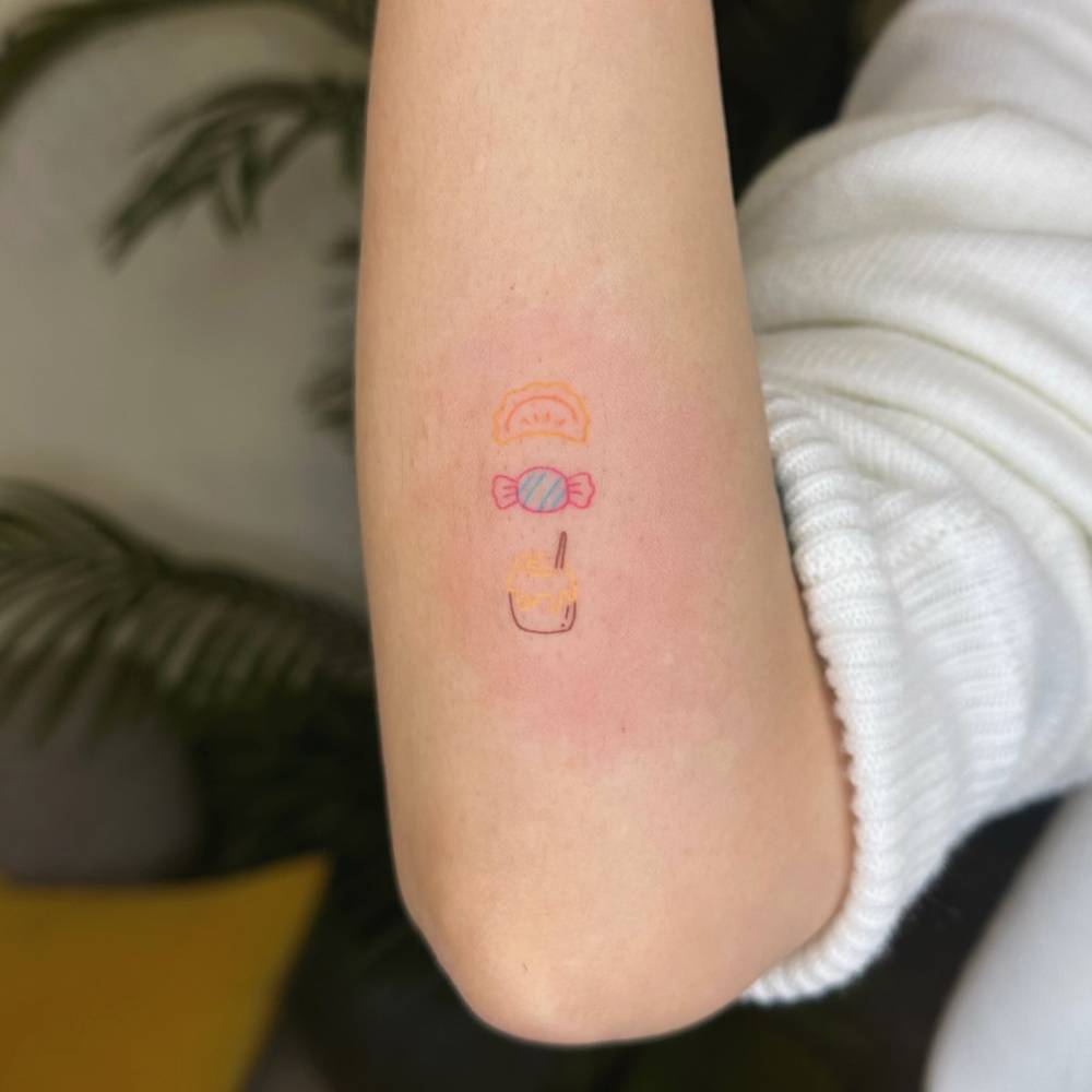 Hand poked dumpling, candy and honey pot tattoo located on the forearm.