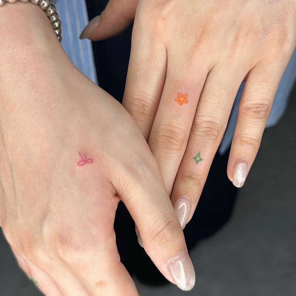 Hand poked bow, flower and star tattoos in minimalistic style.