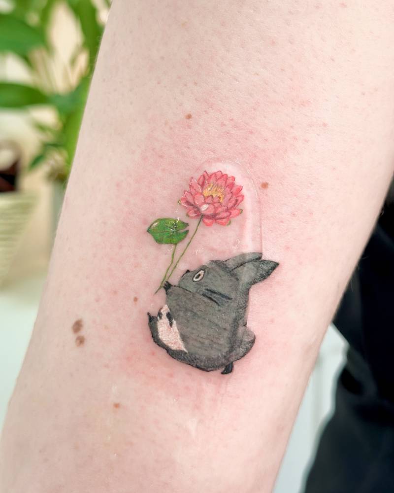 Cartoon style Chuu Totoro tattoo located on the tricep.