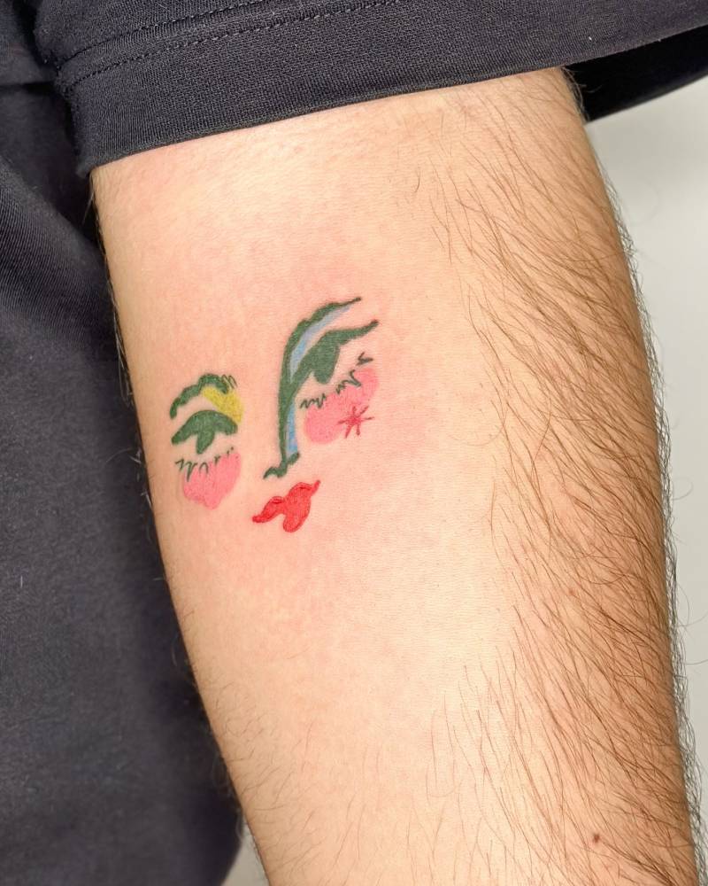 Watercolor style face tattoo done on the inner forearm.