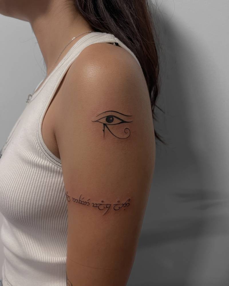 Eye of Horus tattoo in blackwork style located on the upper arm.